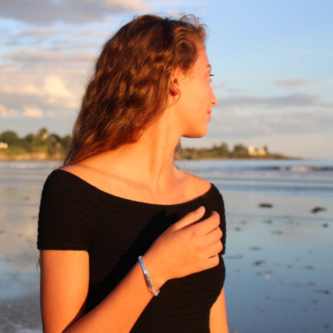 girl on a maine beach wearing a bar bracelet by veda jewelry