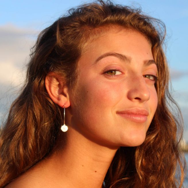 girl on a maine beach wearing veda jewelry chain earring chakra